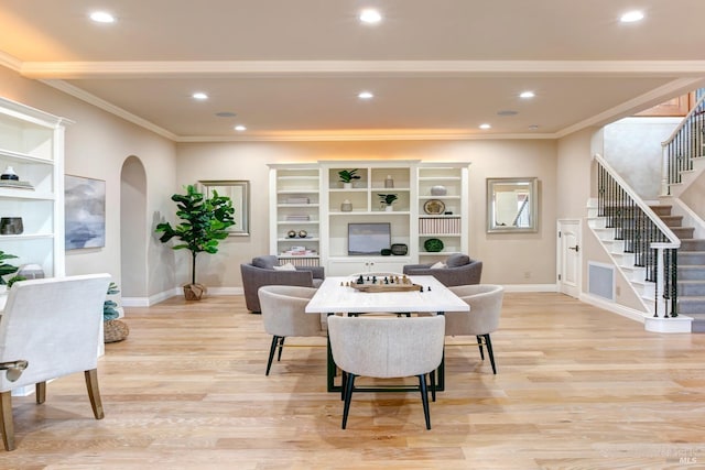 dining area with arched walkways, recessed lighting, stairs, light wood finished floors, and crown molding