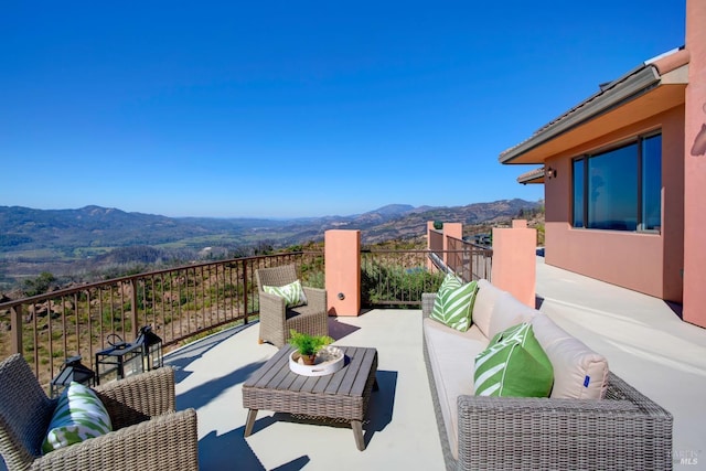 view of patio with outdoor lounge area, a balcony, and a mountain view