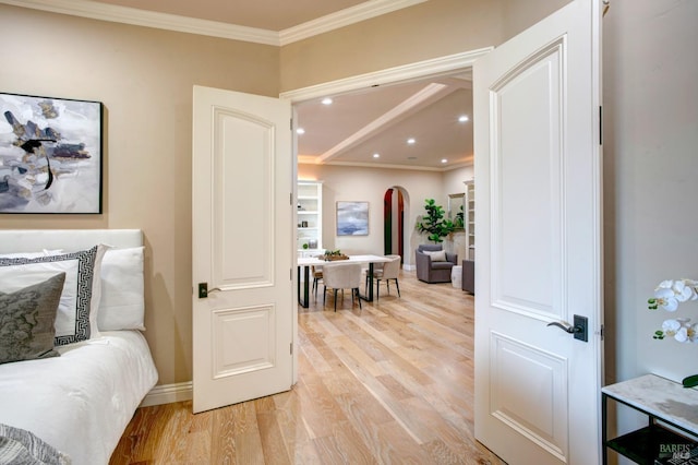 interior space featuring arched walkways, recessed lighting, ornamental molding, light wood-type flooring, and baseboards