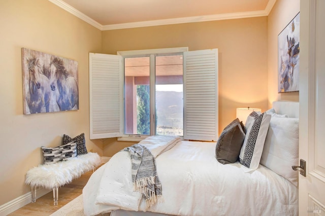 bedroom with ornamental molding, access to exterior, baseboards, and wood finished floors