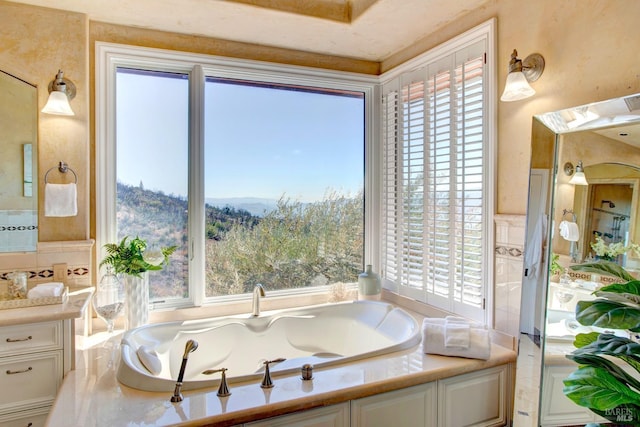 bathroom featuring a tub, plenty of natural light, a mountain view, and vanity