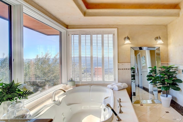 full bath featuring a whirlpool tub, tile patterned flooring, and wainscoting