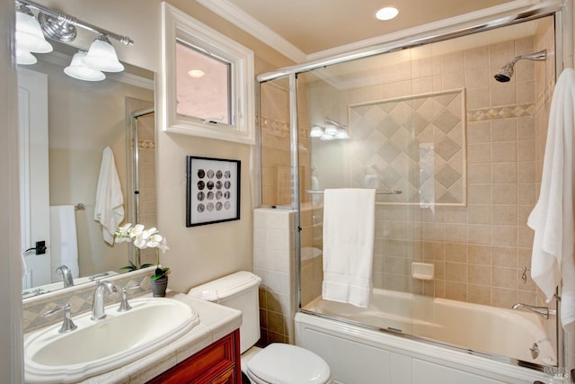 full bath with ornamental molding, vanity, toilet, and bath / shower combo with glass door