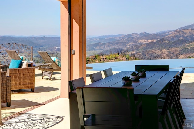 view of patio / terrace with outdoor dining space and a mountain view