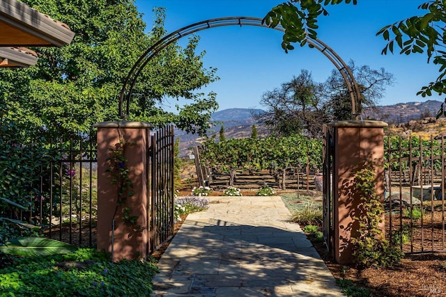 view of gate with fence and a mountain view