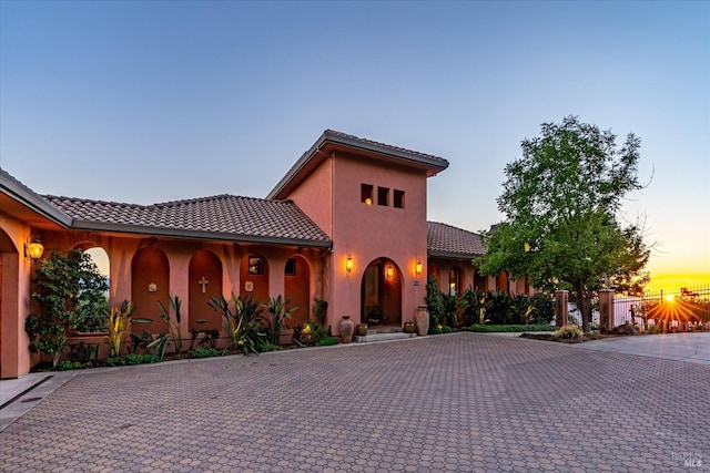 mediterranean / spanish house featuring stucco siding and a tiled roof