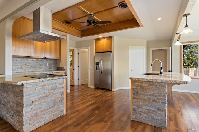 kitchen with dark wood-type flooring, sink, stainless steel fridge, range hood, and a tray ceiling