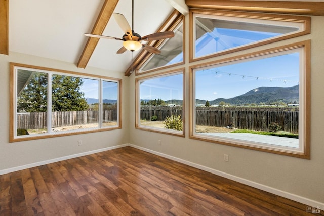 unfurnished sunroom with a mountain view, lofted ceiling with beams, and ceiling fan