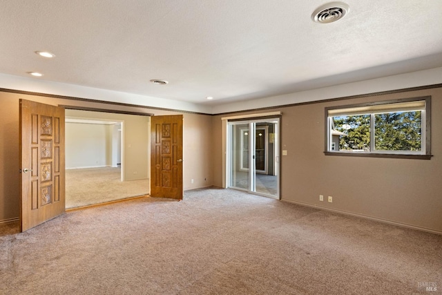 spare room featuring carpet and a textured ceiling