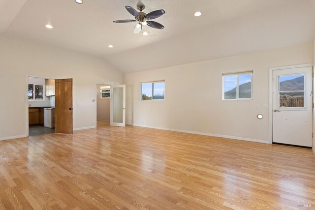 unfurnished living room featuring plenty of natural light, light hardwood / wood-style floors, and lofted ceiling