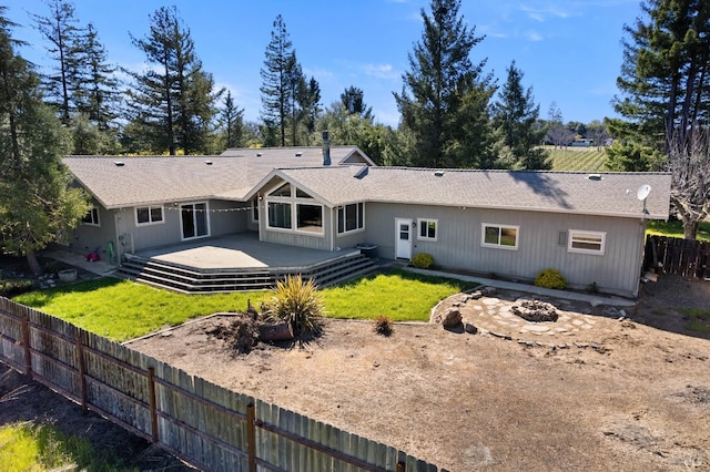 rear view of property featuring a lawn and a wooden deck