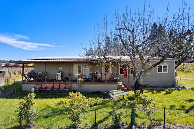 rear view of property featuring a lawn