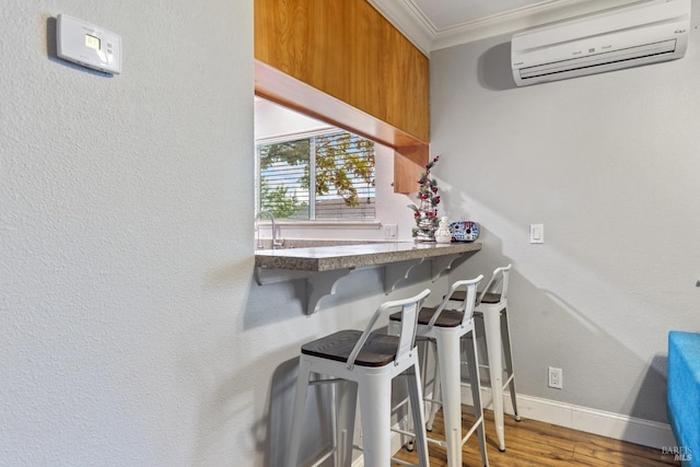 interior space featuring a wall mounted air conditioner, crown molding, and wood-type flooring