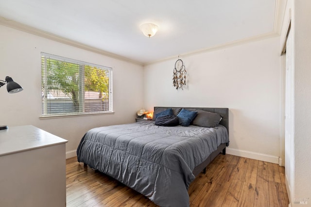 bedroom with ornamental molding and wood-type flooring