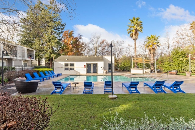 view of swimming pool featuring a patio and a lawn