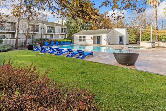 view of swimming pool with a yard, an outdoor structure, and a patio