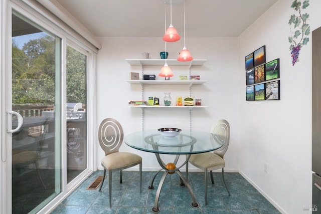 dining space with dark tile patterned floors