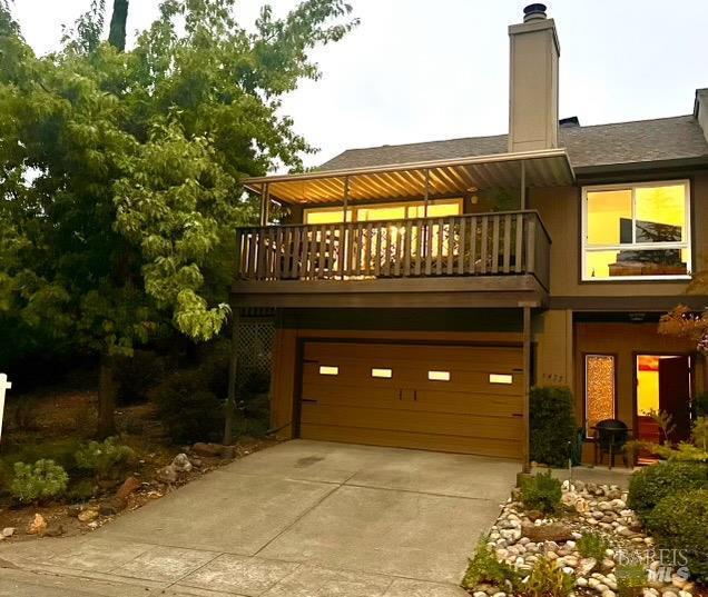 back of house with a balcony and a garage