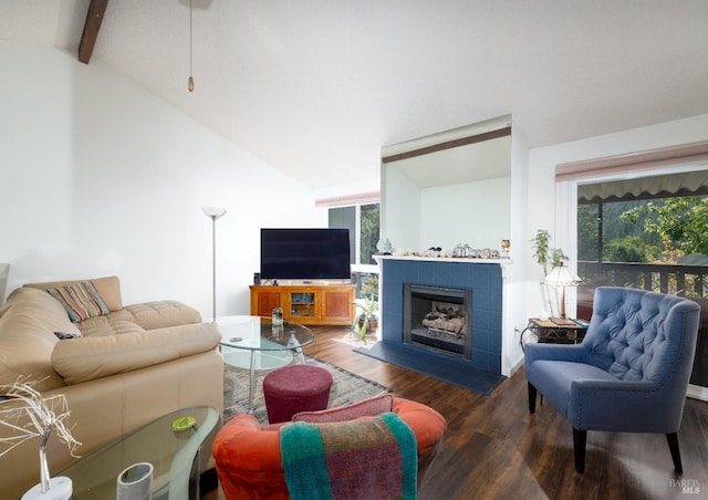 living room with a tile fireplace, lofted ceiling with beams, and dark wood-type flooring