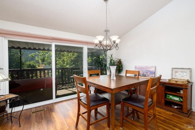 dining space with hardwood / wood-style floors, a chandelier, and a textured ceiling