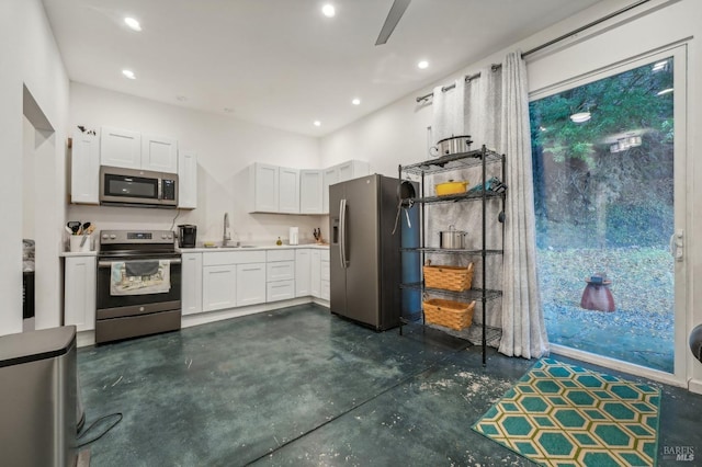 kitchen featuring stainless steel appliances, light countertops, white cabinets, and a sink