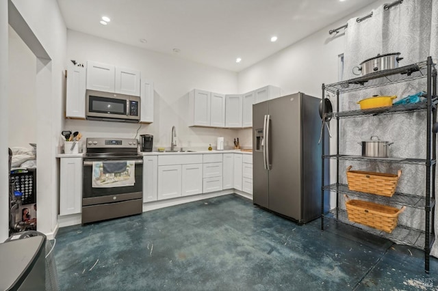 kitchen featuring a sink, stainless steel appliances, light countertops, and white cabinetry