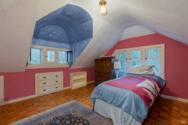 bedroom featuring lofted ceiling, a textured ceiling, and parquet floors