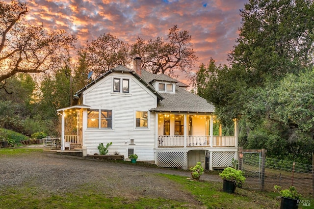 back house at dusk with covered porch