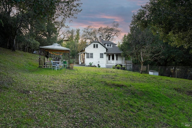 yard at dusk featuring a gazebo