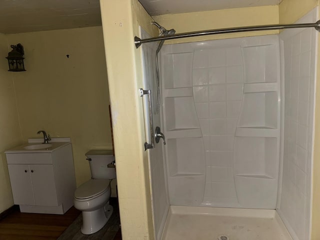 bathroom with walk in shower, vanity, and toilet