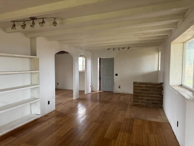 unfurnished room with beamed ceiling, wood-type flooring, and rail lighting