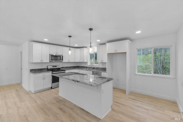 kitchen with white cabinetry, a center island, pendant lighting, and appliances with stainless steel finishes