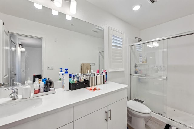 bathroom with tile patterned flooring, vanity, an enclosed shower, and toilet