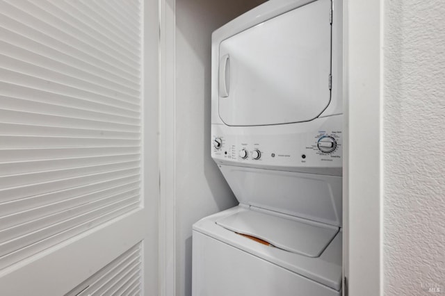 washroom featuring stacked washer and clothes dryer