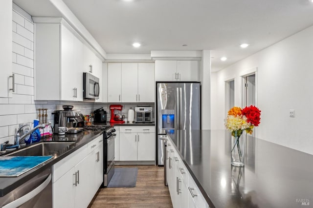 kitchen featuring white cabinets, dark hardwood / wood-style flooring, sink, and appliances with stainless steel finishes