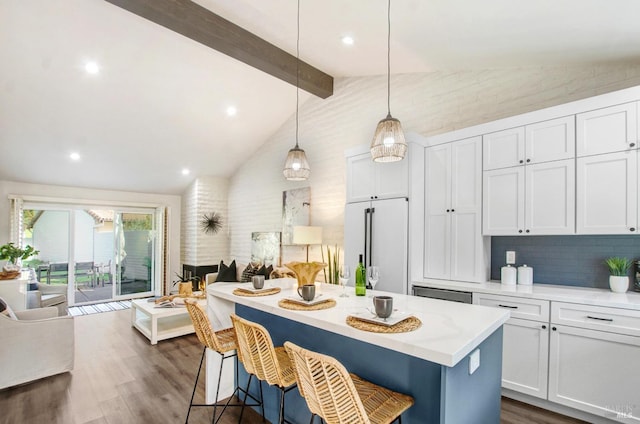 kitchen with high end white refrigerator, dark wood finished floors, a breakfast bar, vaulted ceiling with beams, and light countertops