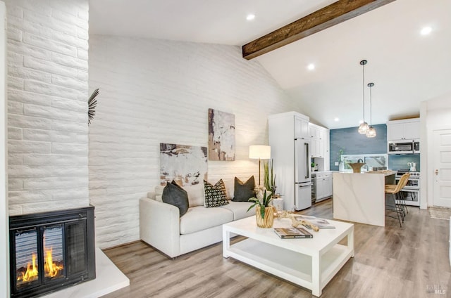 living room with a multi sided fireplace, recessed lighting, light wood-type flooring, and lofted ceiling with beams