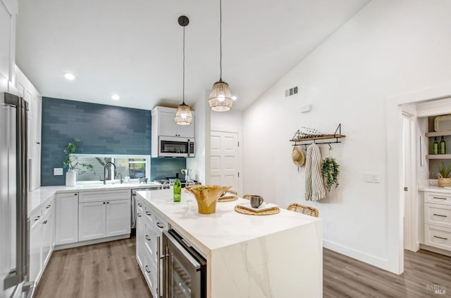 kitchen featuring visible vents, beverage cooler, vaulted ceiling, appliances with stainless steel finishes, and light wood-style floors