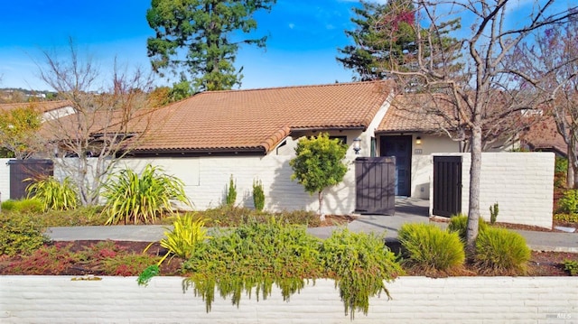 view of front of house featuring fence and a tiled roof