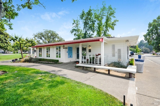 view of front of home featuring covered porch and a front yard