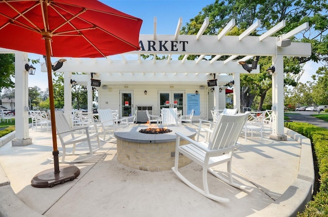 view of patio / terrace with an outdoor fire pit, french doors, and a pergola