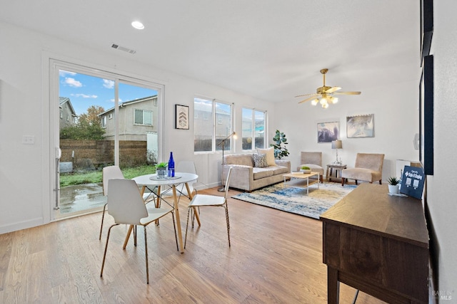 living room with ceiling fan, light hardwood / wood-style floors, and a wealth of natural light