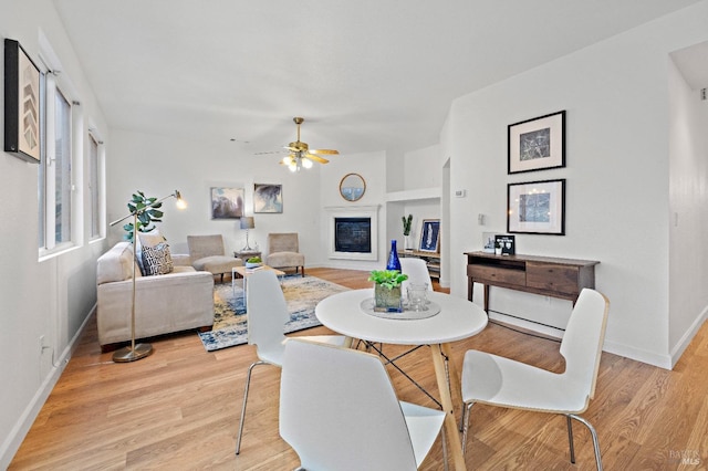 dining area with light hardwood / wood-style floors and ceiling fan