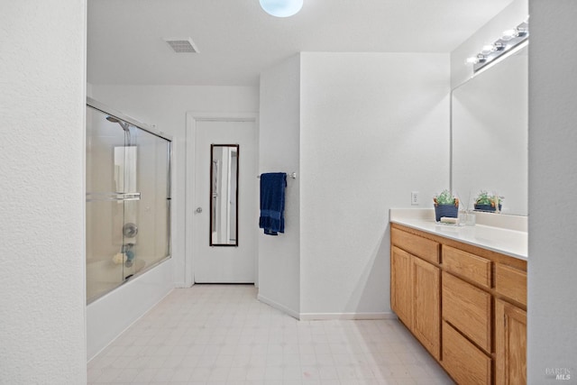 bathroom with vanity and combined bath / shower with glass door