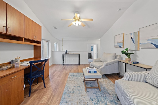 living room featuring light hardwood / wood-style floors, vaulted ceiling, and ceiling fan