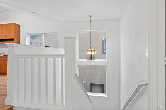 stairway with hardwood / wood-style floors and vaulted ceiling