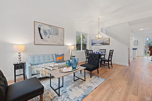 living room featuring a notable chandelier and light wood-type flooring