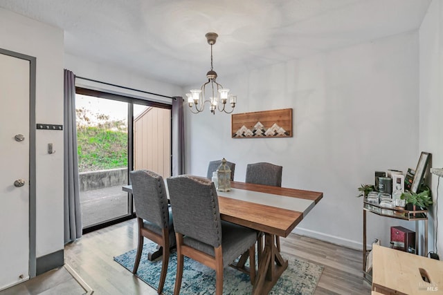 dining space featuring light hardwood / wood-style floors and a notable chandelier