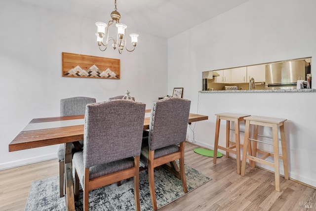 dining area featuring an inviting chandelier and light hardwood / wood-style floors