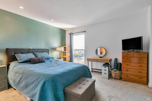 carpeted bedroom featuring a baseboard heating unit and a textured ceiling